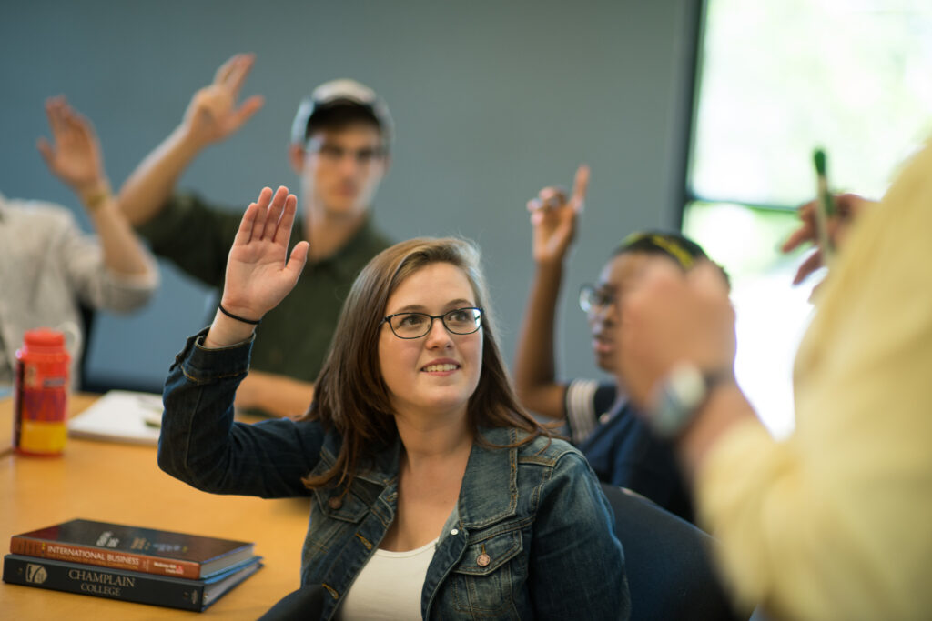 Students with hands raised in a classroom