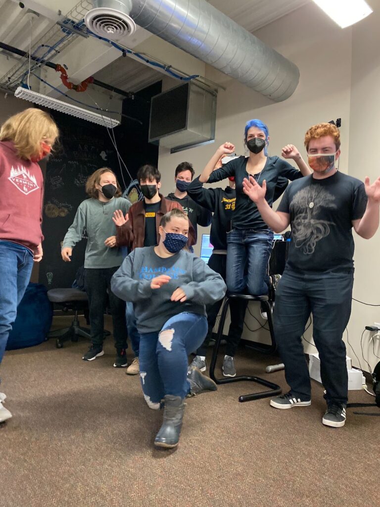 Seven student collaborators wearing masks pose as a team